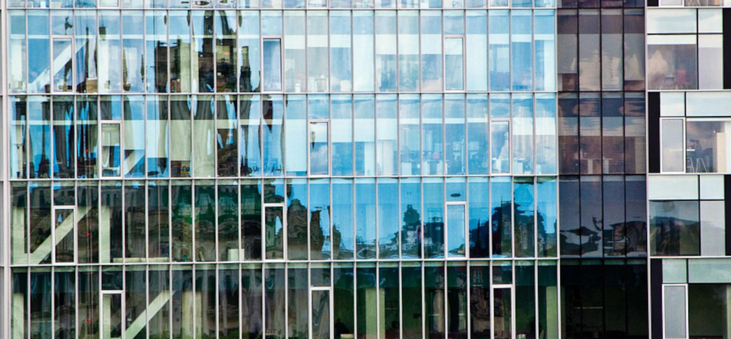 Paysage reflété dans une façade vitrée d'un building